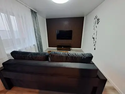 a living room with a couch and a tv at Jaukūs apartamentai centre A. J. Greimo g. in Šiauliai