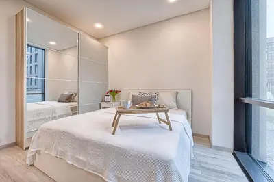 a small bedroom with two beds and a mirror at Business-class apartments 1 x Free parking x SELF CHECK IN 24x7 in Vilnius