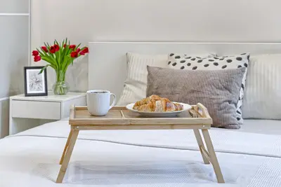 a tray with a plate of pastries on a bed at Business-class apartments 1 x Free parking x SELF CHECK IN 24x7 in Vilnius