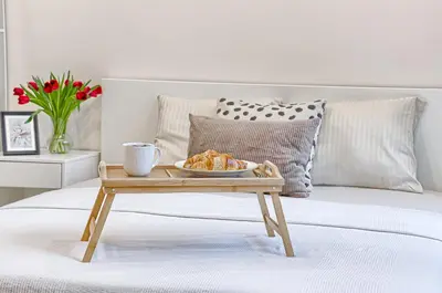 a tray with a plate of food on a bed at Business-class apartments 1 x Free parking x SELF CHECK IN 24x7 in Vilnius