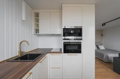 a kitchen with white cabinets and a sink at Old Town view Apartment in city center in Anykščiai