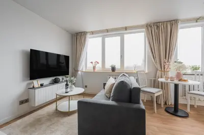 a living room with a couch and a tv at Old Town view Apartment in city center in Anykščiai