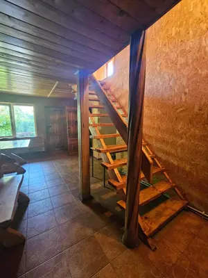 a room with a wooden staircase in a house at Svečiu Namai in Pagiriai