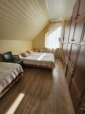 a room with two beds and a chair in it at Svečiu Namai in Pagiriai
