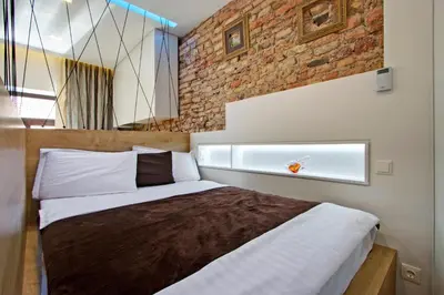 a bedroom with a bed and a brick wall at Angel Wing Apartamentai in Vilnius