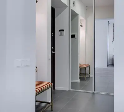 a hallway with a glass door and a bench at Angel Wing Apartamentai in Vilnius