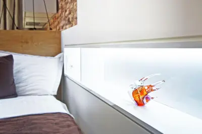 a headboard of a bed with a glass object on it at Angel Wing Apartamentai in Vilnius