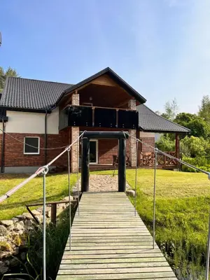 a wooden walkway leading to a house at Pakalnės sodyba in Skverbai