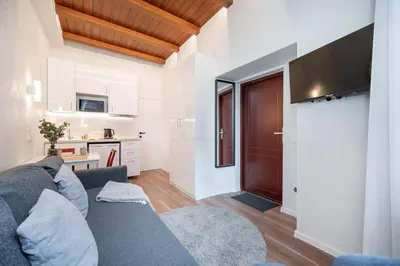 a living room with a blue couch and a kitchen at Cozy studio in the city center in Vilnius