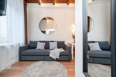 a living room with a blue couch and a mirror at Cozy studio in the city center in Vilnius