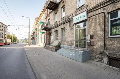 a brick building with a sign on it next to a street at Cozy studio in the city center in Vilnius