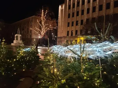a group of christmas trees in a courtyard with lights at Tiny center G studio in Kaunas