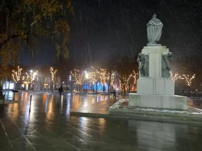a statue in a park in the snow at night at Tiny center G studio in Kaunas