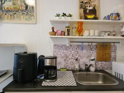 a kitchen counter with a coffee maker and a sink at Tiny center G studio in Kaunas