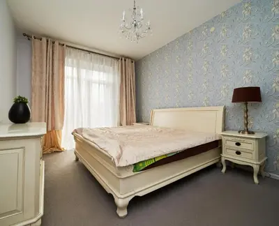 a bedroom with a bed and a chandelier at Cathedral Apartment FREE Parking in Vilnius
