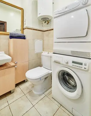 a bathroom with a toilet and a washing machine at Cathedral Apartment FREE Parking in Vilnius
