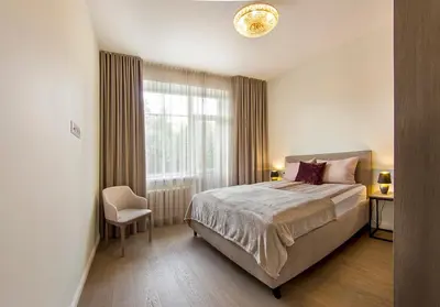 a bedroom with a large bed and a window at Butas Šiaulių mieste in Šiauliai