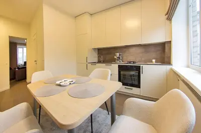 a dining room with a table and chairs in a kitchen at Butas Šiaulių mieste in Šiauliai