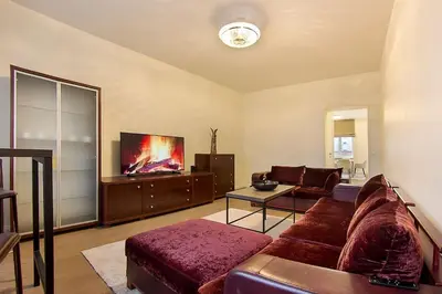 a living room with a couch and a tv at Butas Šiaulių mieste in Šiauliai