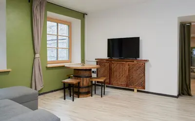 a living room with a tv and a table at Town Hall Apart in Vilnius