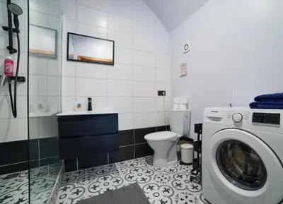 a bathroom with a washing machine and a toilet at Town Hall Apart in Vilnius