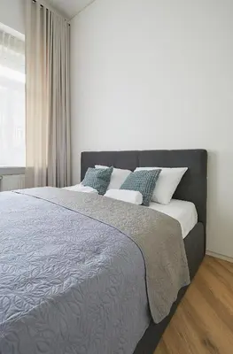 a bedroom with a large bed with blue and white pillows at Kurpiai Old Town, 3BD in Kaunas