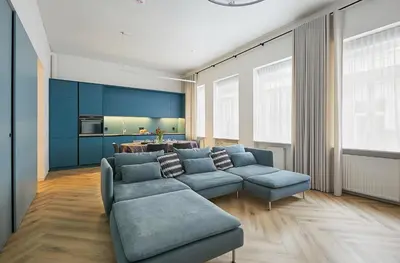 a living room with a blue couch and a table at Kurpiai Old Town, 3BD in Kaunas