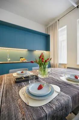 a wooden table with a plate with a strawberry on it at Kurpiai Old Town, 3BD in Kaunas