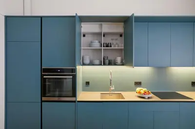 a kitchen with blue cabinets and a bowl of fruit at Kurpiai Old Town, 3BD in Kaunas