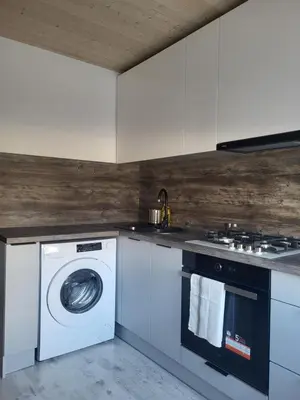 a kitchen with a washing machine and a stove at Poilsis dviems in Šiauliai