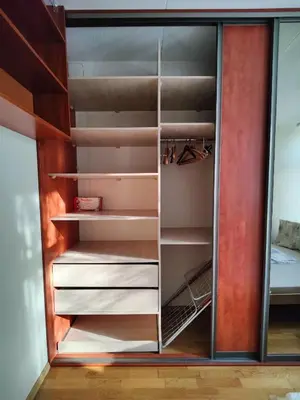a closet with glass doors and shelves at Spacious apartment near old town in Vilnius