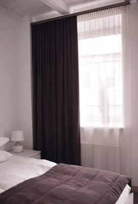 a bedroom with a bed and a large window at Laurentroom Hotel in Ukmergė