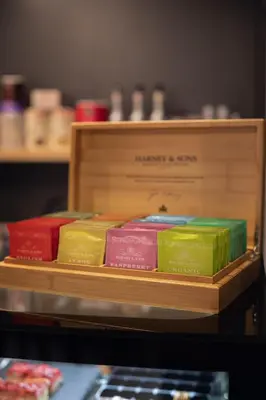 a group of different colored books on a wooden shelf at Laurentroom Hotel in Ukmergė