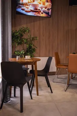 a dining room with a wooden table and chairs at Laurentroom Hotel in Ukmergė