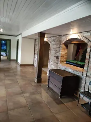 a living room with a stone fireplace and a table at Forest apartment in the loop of the river Neris in Verkšonys