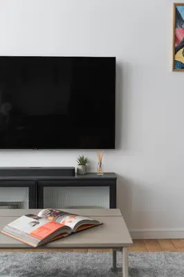 a living room with a tv and a coffee table at City Center Apartment with balcony in Anykščiai