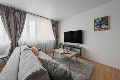 a living room with a couch and a tv at City Center Apartment with balcony in Anykščiai