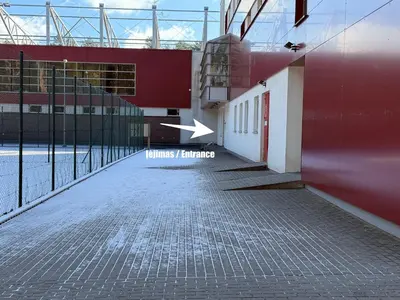 an empty street with an arrow pointing to a building at Alytaus sporto viešbutis Self Check-in in Alytus