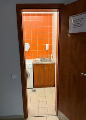 a bathroom with a sink and a washing machine at Alytaus sporto viešbutis Self Check-in in Alytus