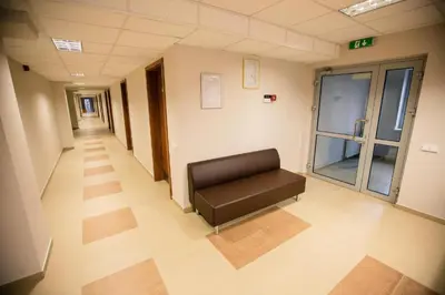 a hospital hallway with a bench in the middle of it at Alytaus sporto viešbutis Self Check-in in Alytus