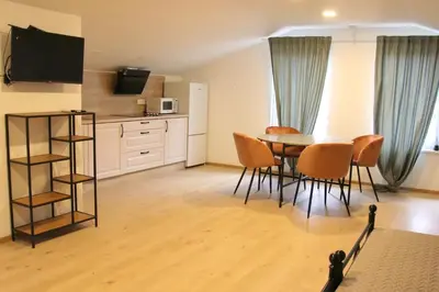 a kitchen and dining room with a table and chairs at Pakalnės sodyba in Skverbai