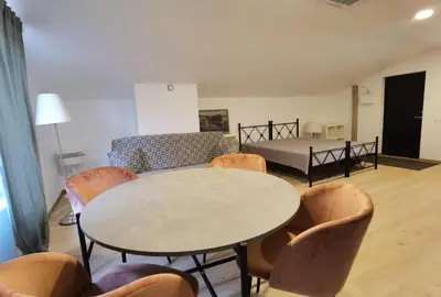 a living room with a table and chairs and a bed at Pakalnės sodyba in Skverbai