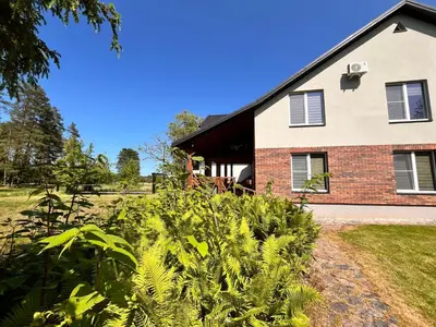 a house with a bunch of plants in front of it at Pakalnės sodyba in Skverbai