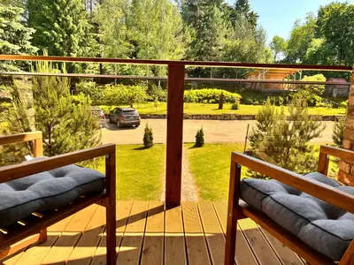 a balcony with two benches and a view of a yard at Pakalnės sodyba in Skverbai