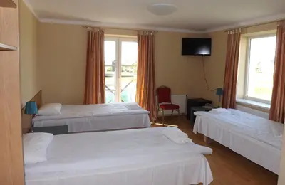 a hotel room with two beds and a television at Kaimo turizmas 