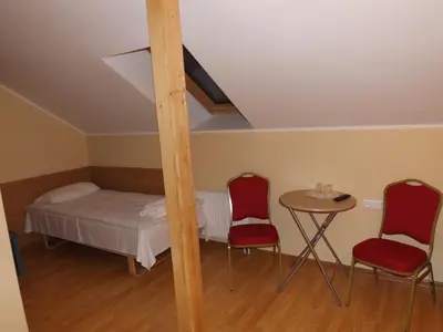 a room with a bed and two chairs and a table at Kaimo turizmas 