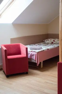 a bedroom with a bed and a chair at Kaimo turizmas 