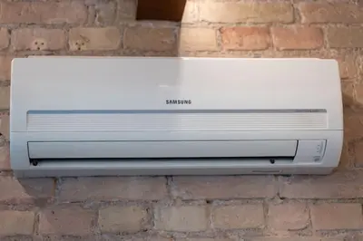 a white computer printer sitting on a brick wall at Warm studio in the heart of city in Vilnius