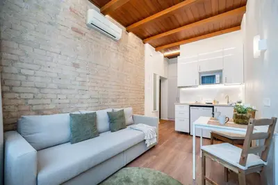 a living room with a couch and a brick wall at Warm studio in the heart of city in Vilnius