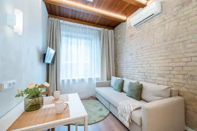 a living room with a couch and a brick wall at Warm studio in the heart of city in Vilnius